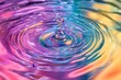 © kribbox - A single water droplet creates colorful ripples in still water.