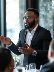 Black business man speaking at a workshop with colleagues in a conference setting
