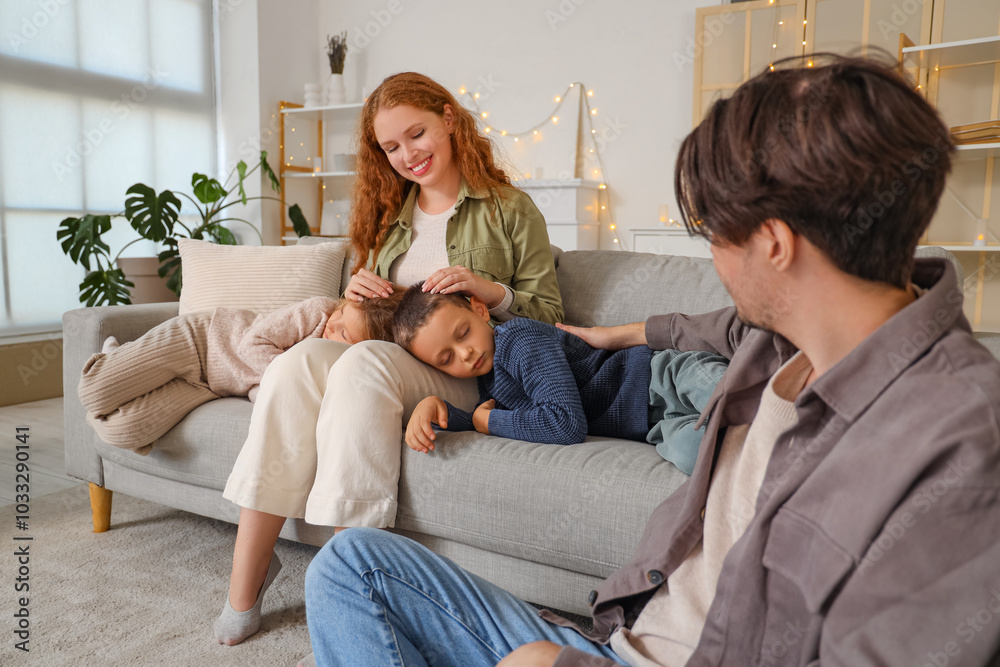 Happy parents with their sleeping little children at home
