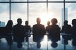 © ARBA - Silhouetted businesspeople gather around a table overlooking a city skyline The meeting is bathed in the warm glow of a sunset