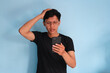 © Lailar Studio - Asian young man looking at his mobile phone with sad expression