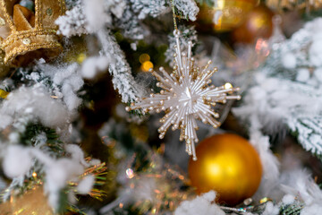 Christmas decorations. A white star on a snow-covered branch of a Christmas tree.