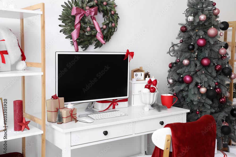 Workplace with computer monitor and Christmas presents in office