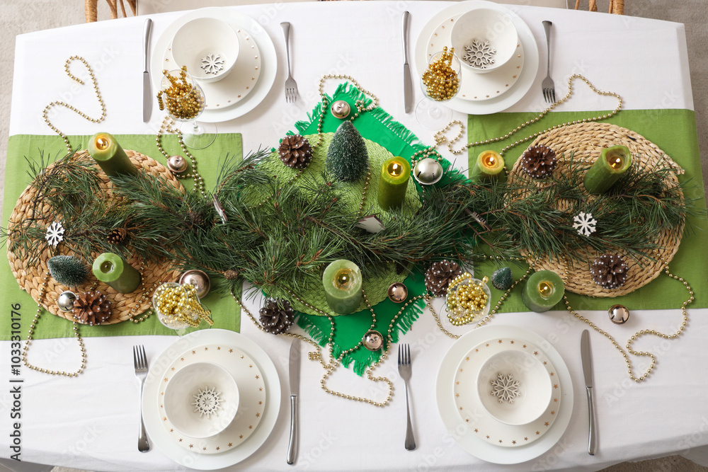 Festive dining table set for Christmas with burning candles and fir branches, top view