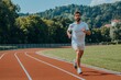 © Pooja - Fit athlete running race in athletics racetrack on a sunny day