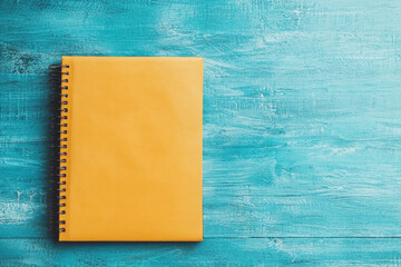 A bright yellow notepad lies on a textured blue background, perfect for notes and doodles.