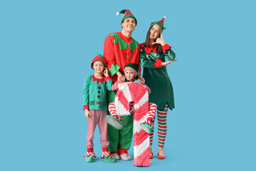 Poster - Happy family in elf's costumes with candy cane pinata showing 