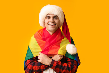 Poster - Young man in Santa hat with LGBT flag on yellow background