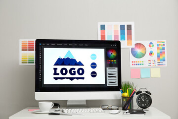 Fototapete - Workplace of graphic designer with modern computer, alarm clock and color charts on white table
