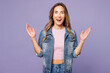 © ViDi Studio - Young shocked surprised happy cool woman she wear denim jacket violet top casual clothes look camera spread hands isolated on plain pastel light purple background studio portrait. Lifestyle concept.