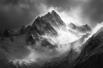 Wall Mural - a dramatic black and white photograph of a snow-capped mountain peak shrouded in mist with the sun b