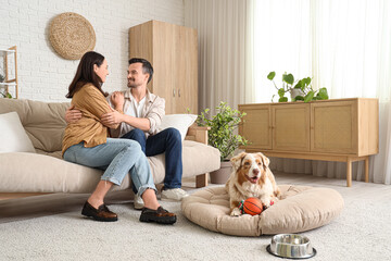 Wall Mural - Young couple and Australian Shepherd dog with toys at home