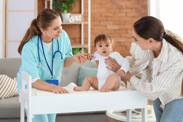 Poster - Female pediatrician with little baby on changing table and mother at home