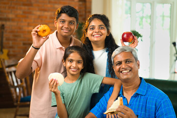 Indian Asian family of four enjoying quality time together around the dining table at home