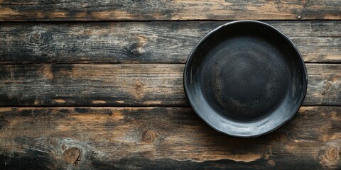 Aufkleber - Table arrangement featuring a vintage empty black plate on rustic wood. Dark backdrop. Top view. Copy space.