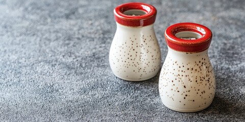 Poster - Vintage white and red ceramic salt and pepper shakers on a concrete background. Copy space for text.