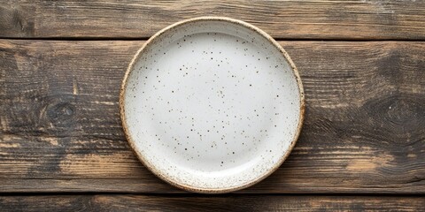 Poster - Empty ceramic plate on a wooden surface. Top view with copyspace.