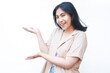 © M Alfan Setyawan - excited asian woman pointing finger showing presenting gesture wearing casual clothes isolated on white background