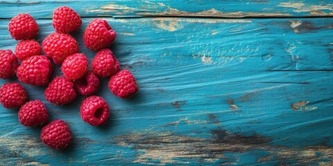 Poster - A cluster of raspberries on a vibrant wooden table background. Close-up composition with copy space for text.