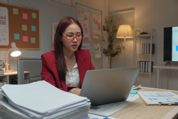 Young independent businesswoman with glasses is tired, stressed, has a headache while sitting in front of a laptop for a long time and working in finance. Online. Office Syndrome concept.