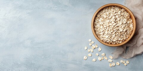 Poster - Dry oatmeal in a bowl on a light background. Healthy breakfast. Concept of dieting and weight loss. Flat lay, top view, copyspace.