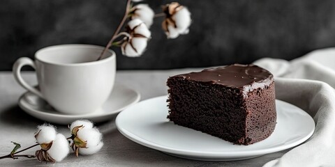Aufkleber - Delicious chocolate cake on a white plate, accompanied by a ceramic cup and cotton flowers, set against a grey background for Sunday morning breakfast.