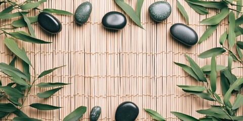 Poster - Acupuncture needles, spa stones, and green leaves arranged on a bamboo mat, viewed from above. Room for text.