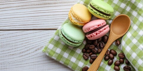 Poster - Colored macaroons and a wooden spoon with coffee beans on a green plaid towel, set against a light wooden background.
