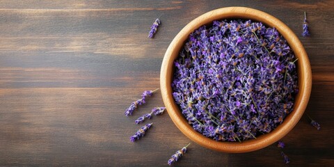 Poster - Dried lavender flowers in a wooden bowl on the table. Top view.