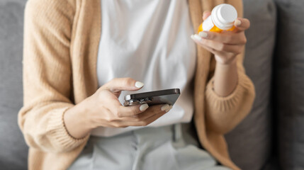 asian woman search for information on internet in smartphone with holding bottled drug. girl reading
