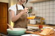 © Prathankarnpap - Young asian woman wearing an apron whisking eggs in a glass bowl at kitchen counter
