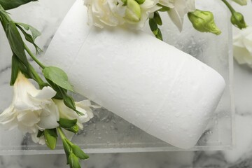 Wall Mural - Solid deodorant and beautiful eustoma flowers on white marble table, top view