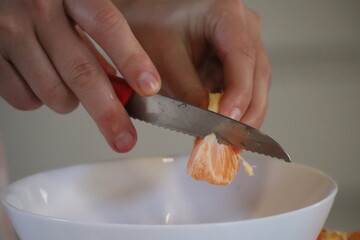 Young female hands manipulate tangerine