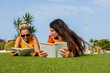 © ADDICTIVE STOCK - Mother and transgender daughter enjoying a book outdoors