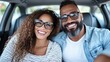 © Pinklife - A joyful couple wearing glasses, sitting inside a contemporary car, radiating happiness and warmth. The interior complements their stylish and cheerful demeanor.