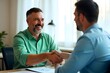 © NISHAN'S STUDIO - Smiling middle aged business man handshaking partner making partnership collaboration agreement at office meeting, hr manager and new worker shake hands recruiting at job interview