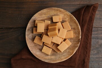 Sticker - Tasty sweet caramel candies on wooden table, top view