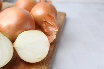 Sticker - Fresh onions with peels on white tiled table, closeup. Space for text