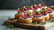 © Andrii - Gourmet fig and goat cheese crostini appetizers on rustic wooden board. Fresh figs, creamy cheese, and herbs create an elegant and colorful display for a sophisticated party spread.