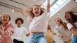 © fotofabrika - Joyful children dancing together in a bright studio during a fun group activity on a sunny day
