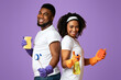 © Prostock-studio - Happy african american couple holding cleaning supplies posing over pink studio background, standing back to back and smiling, free space