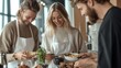 © Sansern - Three friends laughing and enjoying a meal together in a modern kitchen.