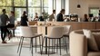 © Sansern - Modern office break room with people gathered around a coffee bar and lounge seating.