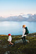 © EVERST - Family traveling mother and child hiking in mountains of Norway backpacking trip in the wild nature, healthy lifestyle vacations outdoor, mom with backpack and kid enjoying Lyngen Alps and fjord view