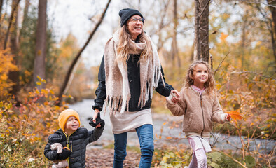 joyful mom and her childs. mother and child have fun, laugh and enjoy nature outdoors at autumn park