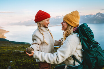 Wall Mural - Mother and daughter traveling together family hiking in mountains, healthy lifestyle outdoor active vacations tour in Norway, woman backpacker having fun with child candid emotions, Mothers day