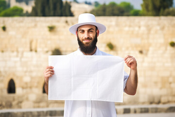 Canvas Print - An oriental man with a poster in his hands on a bright background, expressing emotions, ready to share an important message