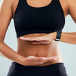 © SensSai/peopleimages.com - Woman, hands and fitness with frame on stomach for diet, health and wellness on a gray studio background. Closeup, female person or body with abdomen for gut digestion, weight loss or liposuction
