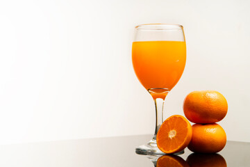 Delicious freshly squeezed orange juice in the glass from organic oranges isolated on white background with copy space