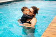 © kleberpicui - Happy Brazilian boy with his mother having fun in the swimming pool